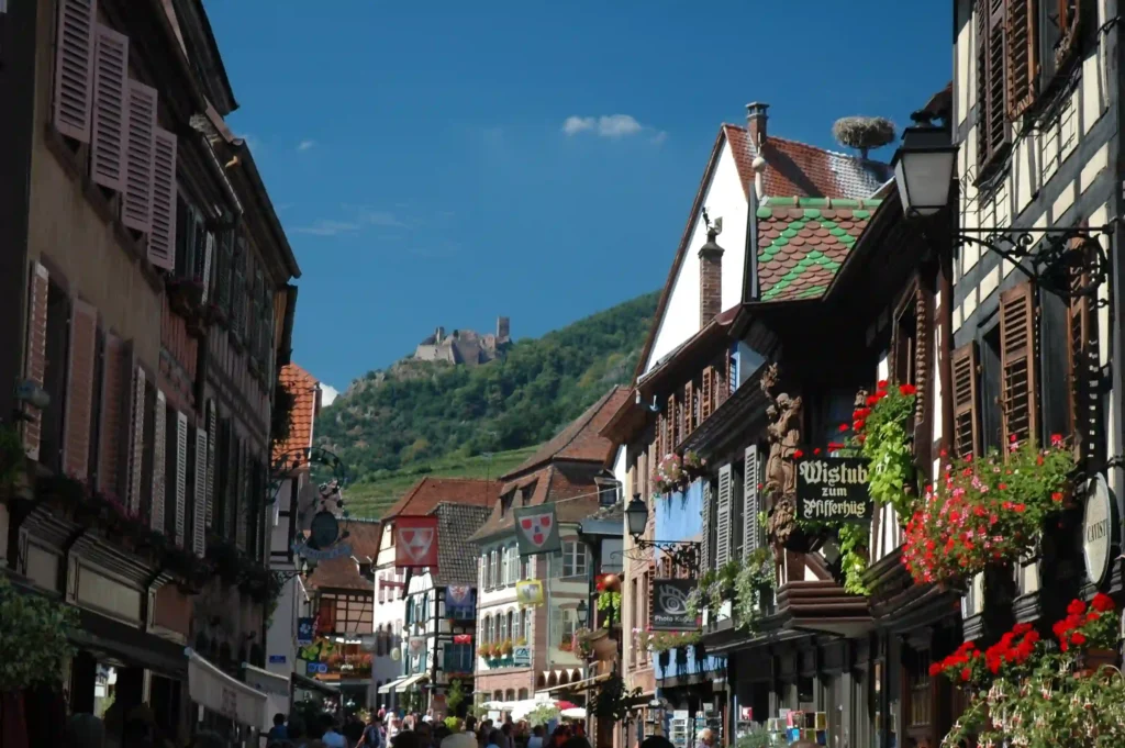 Calle principal de Ribeauville con las ruinas del castillo al fondo