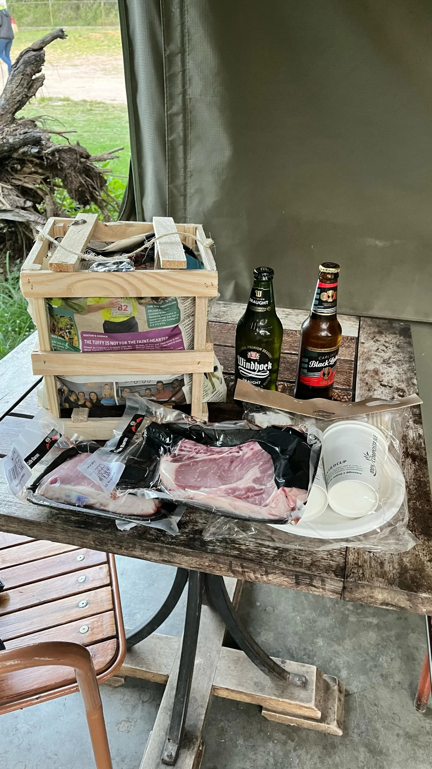 Mesa con paquetes de carne envasada y botellas de cerveza para una barbacoa