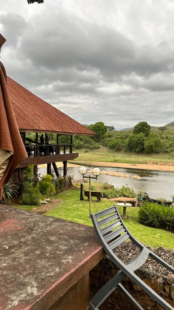 Terraza y jardín del River House Lodge con vistas al río Crocodile junto a la puerta Malelane
