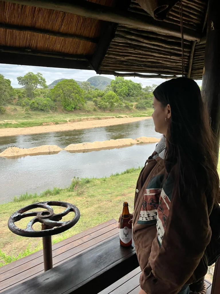 Mujer observando un río desde un mirador cubierto en el River House Lodge