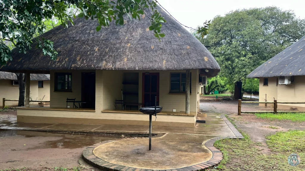 Exterior de un bungalow circular con techo de paja y zona de barbacoa en Lower Sabie