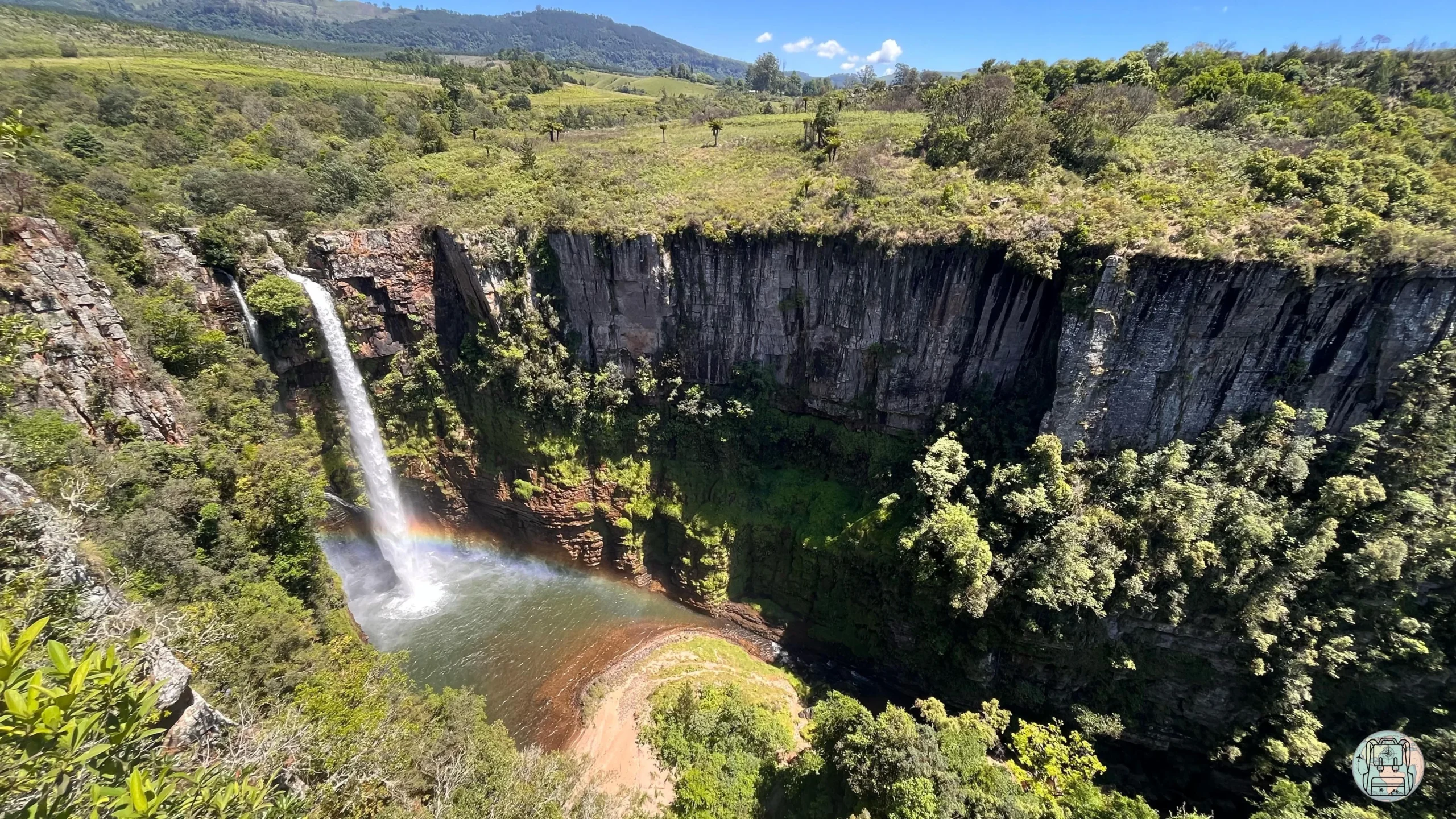 Vista panorámica de la cascada Mac Mac Falls cayendo en un profundo cañón verde con un arcoíris en la base